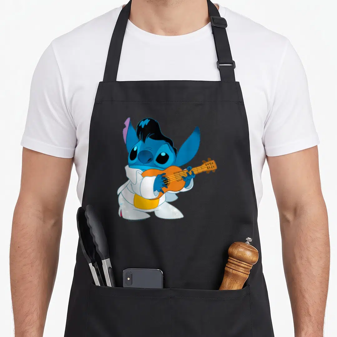 Iconic stitch apron - Blue cartoon alien in white gi playing orange ukulele — shown on a black cotton canvas apron against a white background