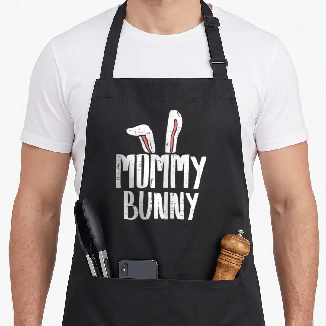 Ear easter bunny aprons - MOMMY BUNNY text with two white bunny ears containing red vertical stripes — shown on a black cotton canvas apron against a white background