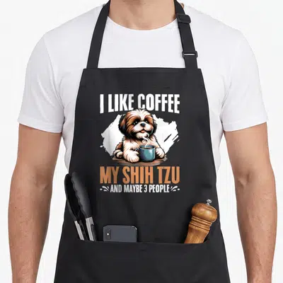 Coffee shih dog apron - Cartoon Shih Tzu holding blue mug with I Like Coffee My Shih Tzu text — shown on a black cotton canvas apron against a white background
