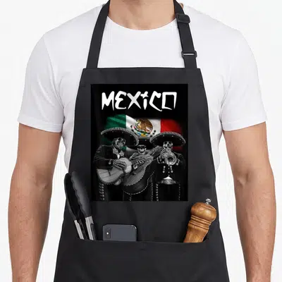 Mariachi skull mexican apron - MEXICO text above flag and three skeleton mariachi musicians in black and white — shown on a black cotton canvas apron against a white background