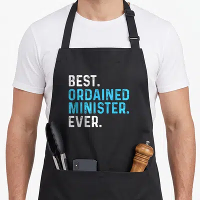 Ordained minister wedding apron - Stacked white and blue distressed text reading BEST. ORDAINED MINISTER. EVER — shown on a black cotton canvas apron against a white background