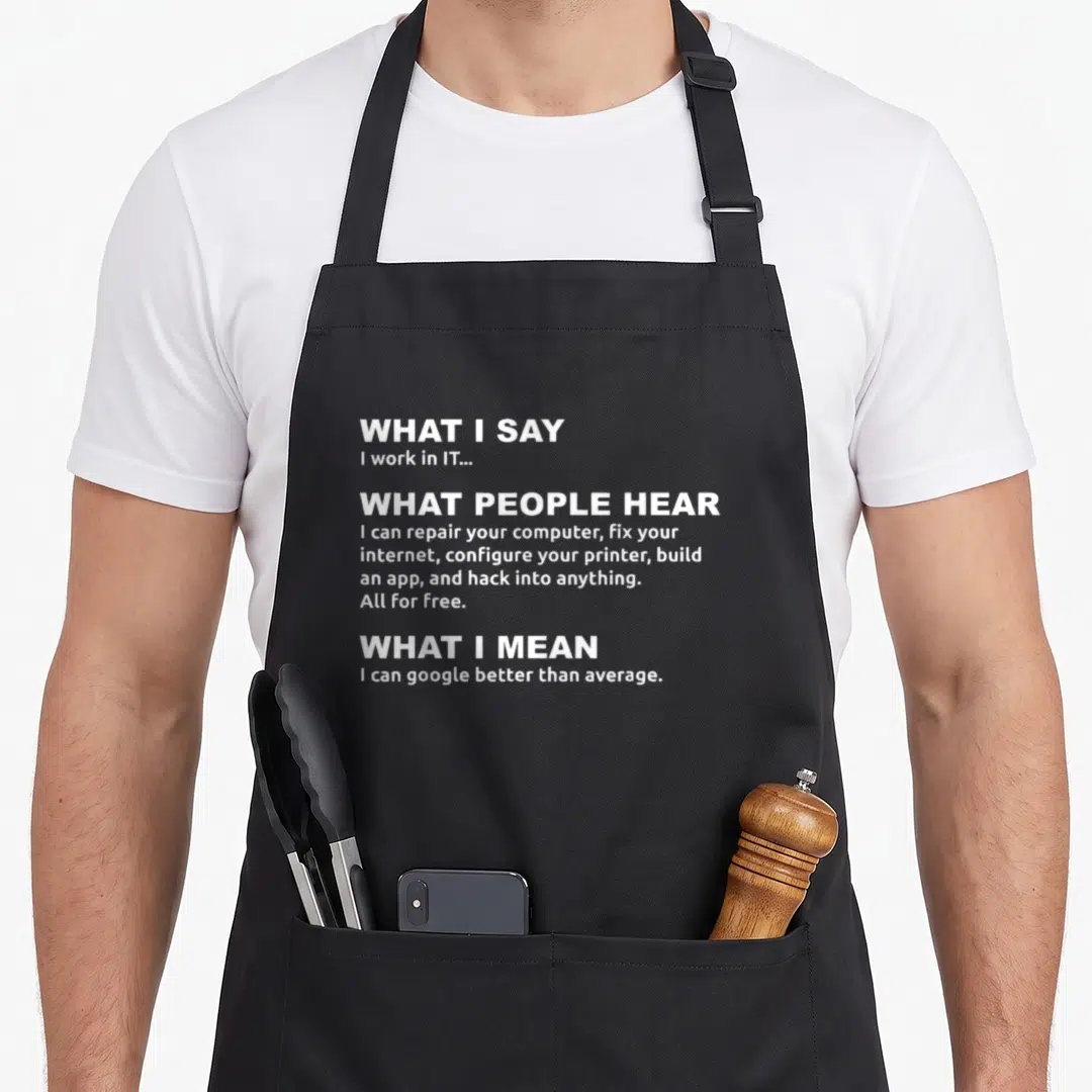 Google professional apron - White stacked text reading WHAT I SAY I work in IT on black apron — shown on a black cotton canvas apron against a white background
