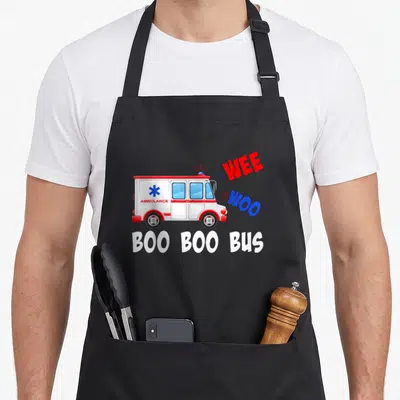 Wee medic apron - Cartoon ambulance with WEE WOO and BOO BOO BUS text in red blue and white — shown on a black cotton canvas apron against a white background