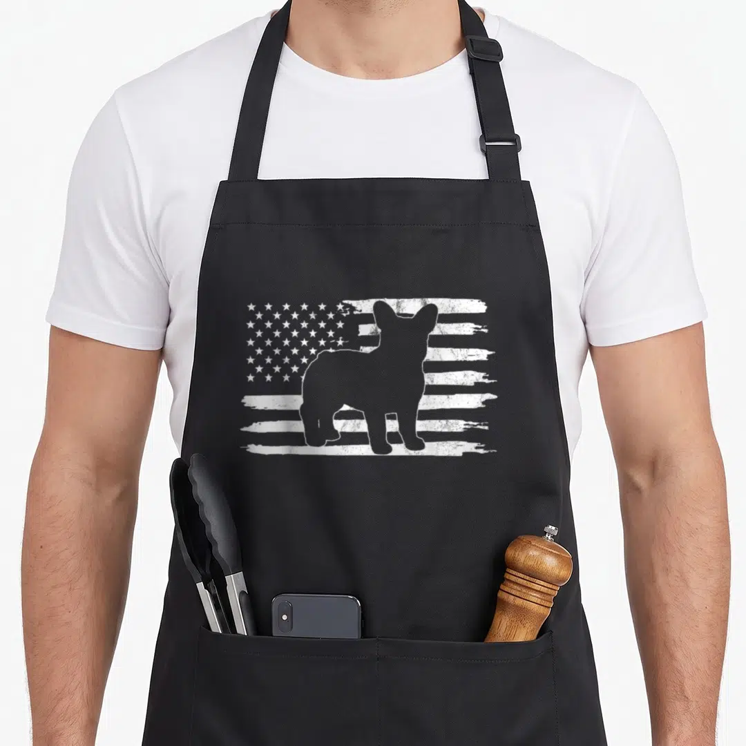 4th french apron - Grey dog silhouette standing before a distressed white flag pattern — shown on a black cotton canvas apron against a white background