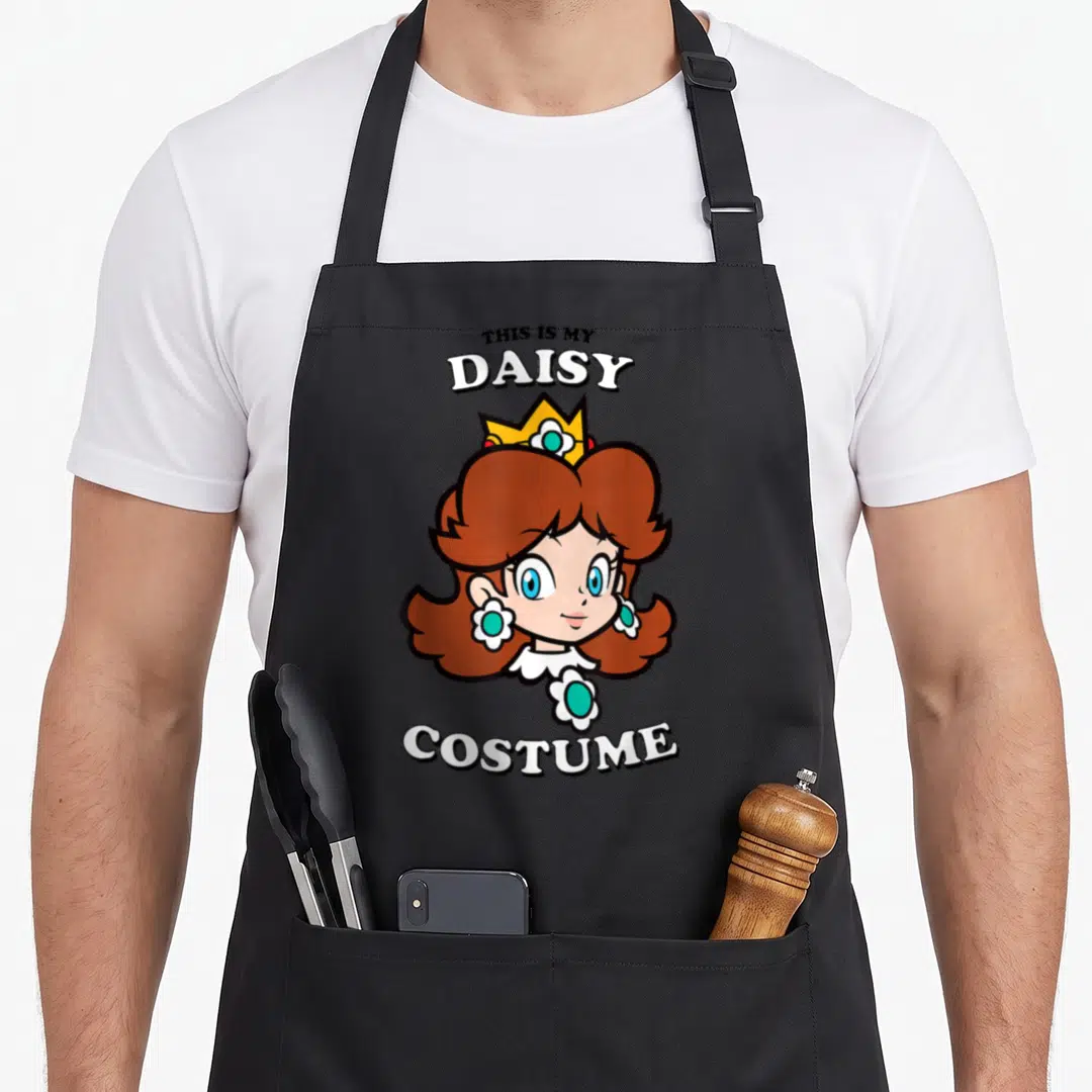 Costume daisy apron - Princess Daisy cartoon graphic with THIS IS MY DAISY COSTUME text — shown on a black cotton canvas apron against a white background