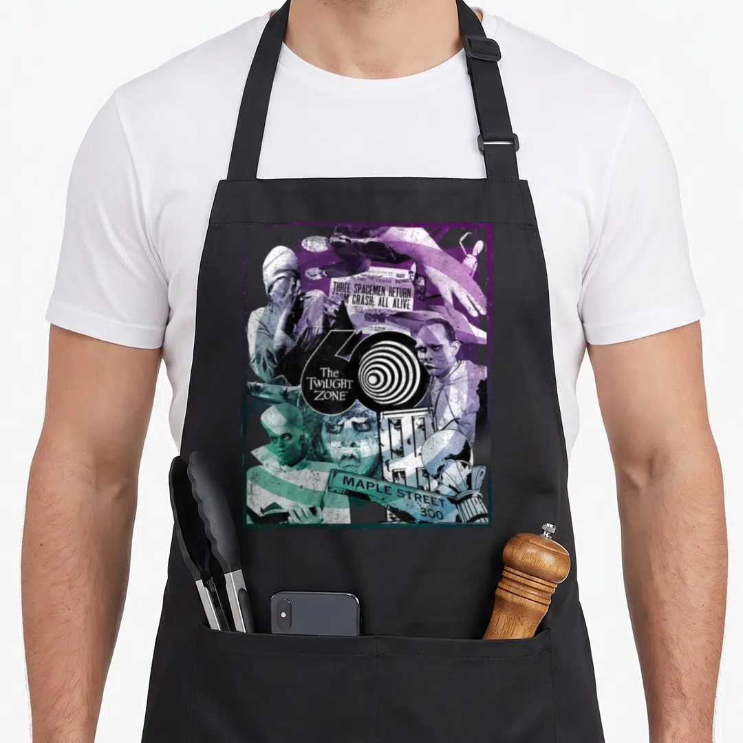60th twilight apron - Twilight Zone 60th anniversary collage with newspaper headline and spiral logo in purple and teal — shown on a black cotton canvas apron against a white background
