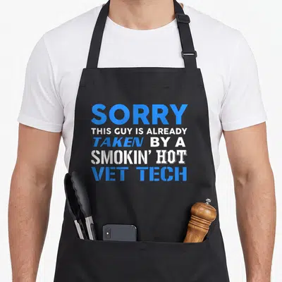 Taken husband apron - Blue and white stacked text reading Sorry This Guy Is Already Taken By A Smokin Hot Vet Tech — shown on a black cotton canvas apron against a white background