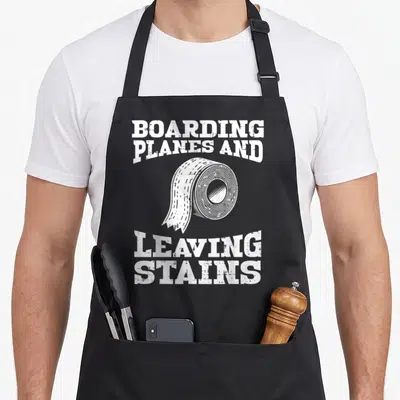 Boarding inappropriate apron - White distressed text arched around a roll of tape on black fabric — shown on a black cotton canvas apron against a white background