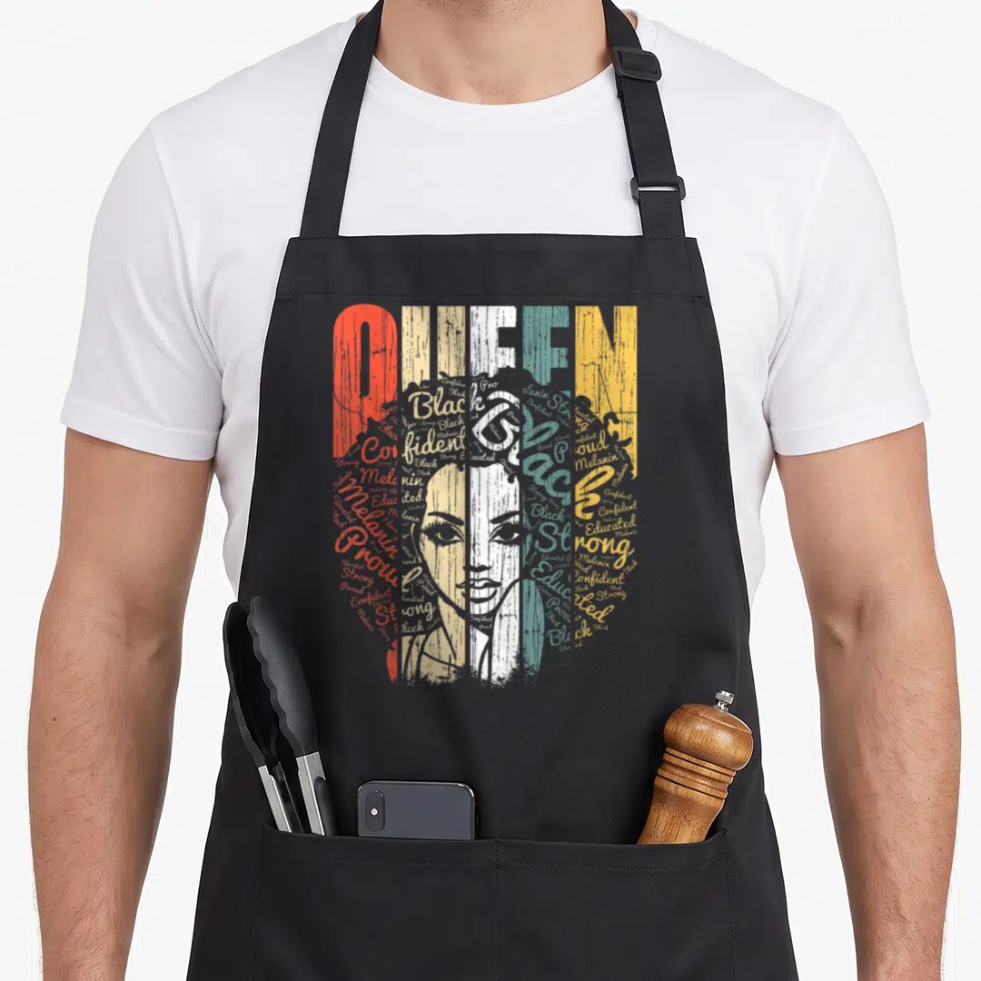 Queen chef outfit apron - Typography portrait of a woman formed by words Confident, Strong, Educated, Melanin, Proud — shown on a black cotton canvas apron against a white background