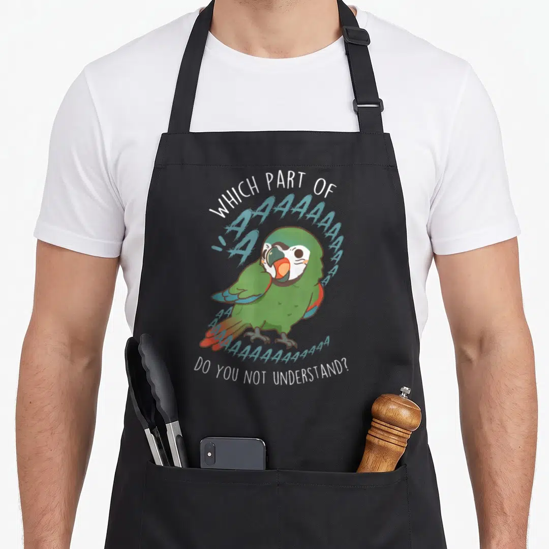Severe pet apron - Green cartoon parrot with screaming A's and sarcastic quote text — shown on a black cotton canvas apron against a white background