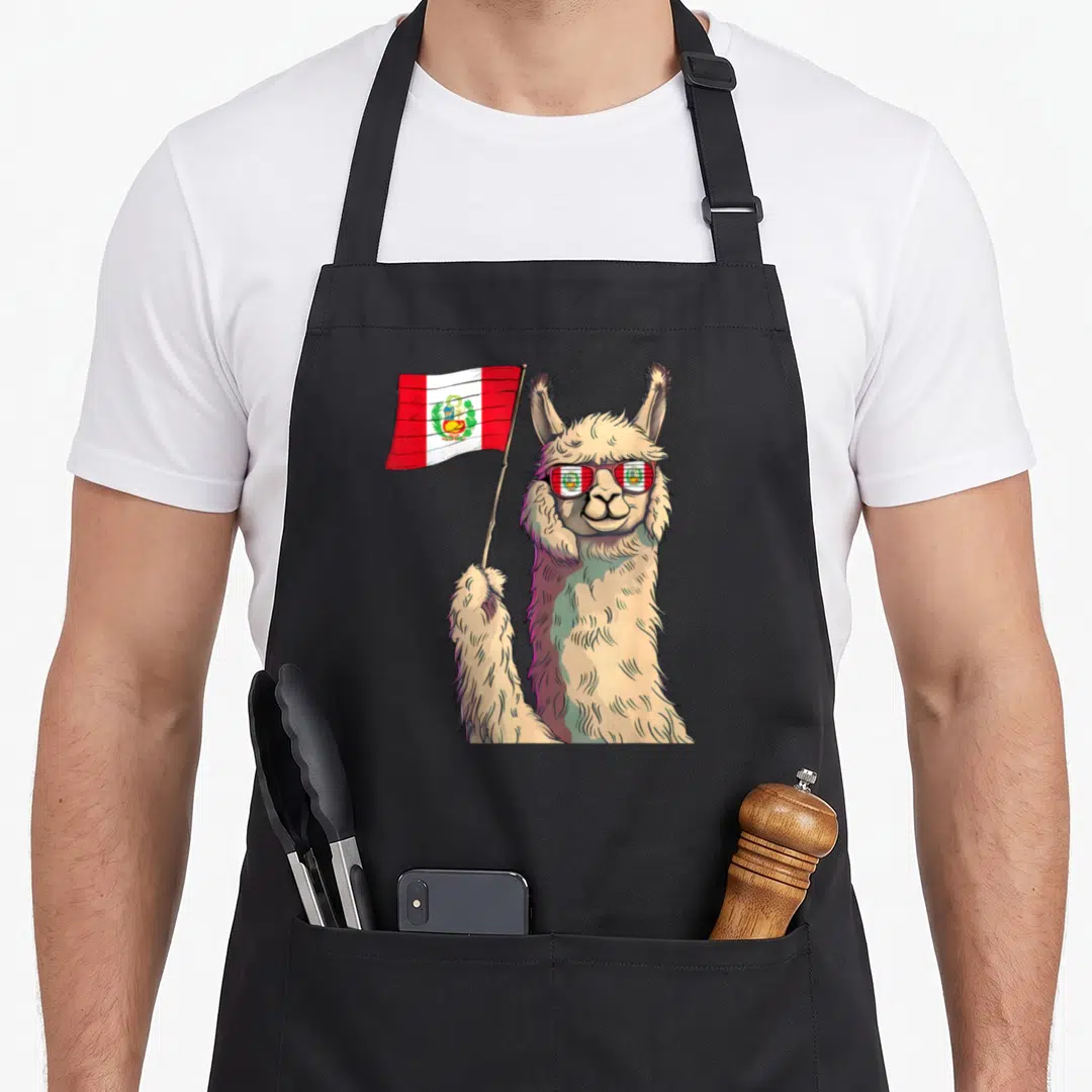 Alpaca pride apron - Cartoon beige llama holding red white Peruvian flag wearing matching sunglasses — shown on a black cotton canvas apron against a white background
