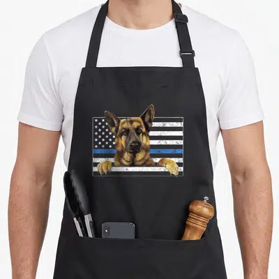 Thin dog mom apron - Realistic German Shepherd head and paws over distressed flag with blue stripe — shown on a black cotton canvas apron against a white background
