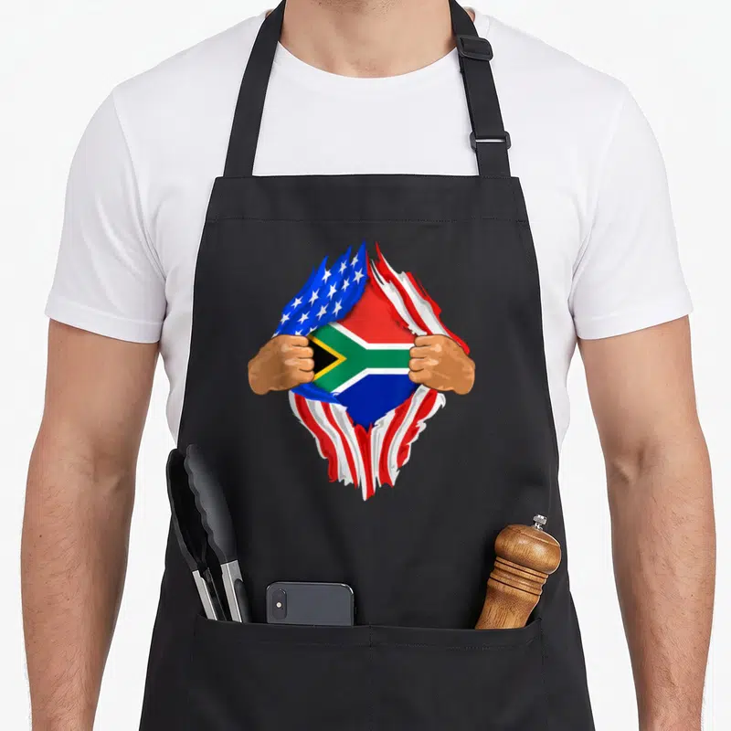 Blood south african apron - Two hands tearing USA flag revealing South African flag with red blue green yellow stripes — shown on a black cotton canvas apron against a white background