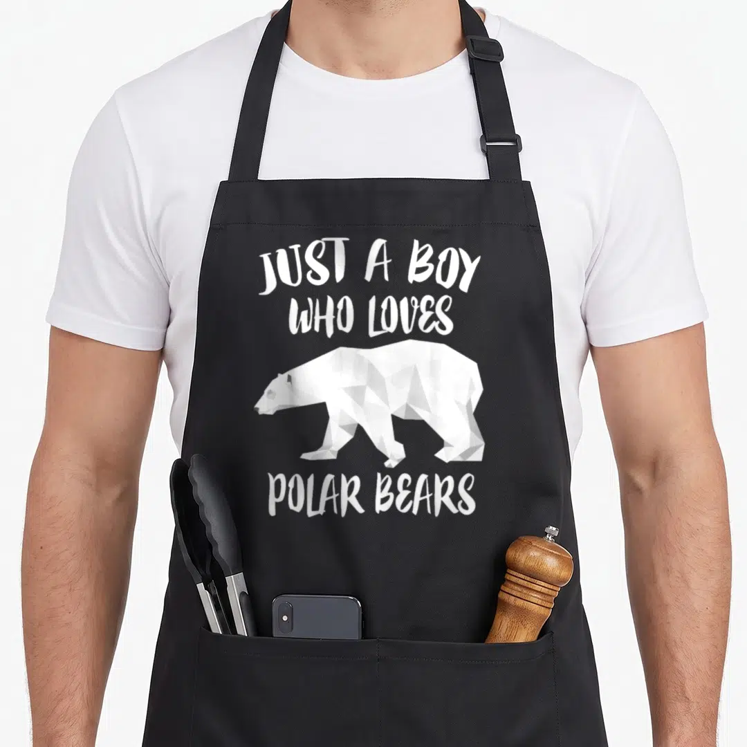 Retro polar bear apron - White geometric polar bear walking beneath text reading JUST A BOY WHO LOVES POLAR BEARS — shown on a black cotton canvas apron against a white background