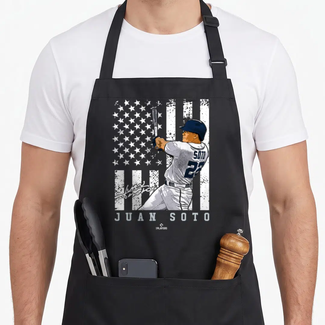 Show new york apron - Baseball player batting in front of distressed flag with SOTO 222 text — shown on a black cotton canvas apron against a white background
