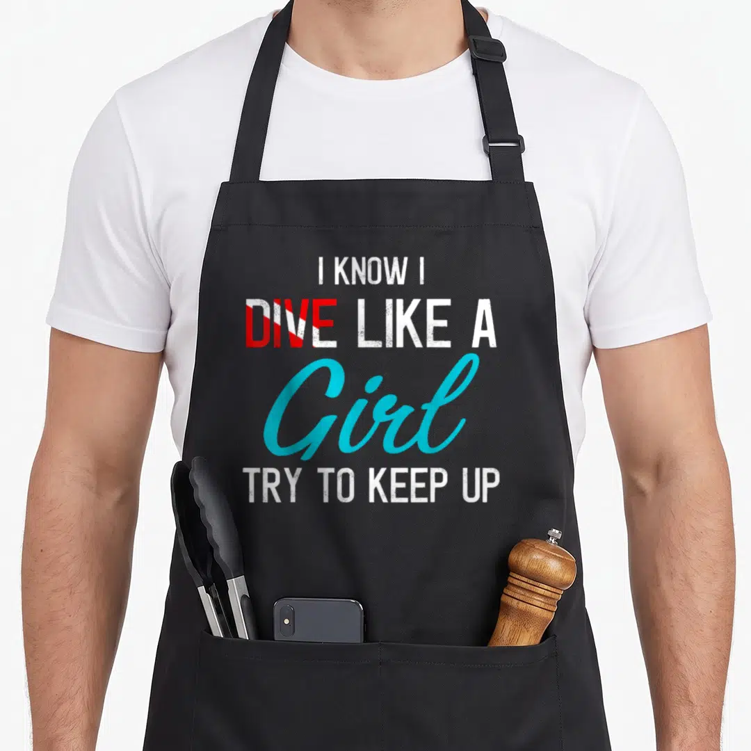 Scuba diver diving apron - Stacked text I KNOW I DIVE LIKE A Girl TRY TO KEEP UP in white blue and red — shown on a black cotton canvas apron against a white background