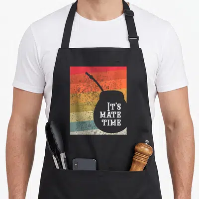 Argentine yerba mate apron - Grey mate gourd silhouette with IT'S MATE TIME text over red orange yellow grey and teal — shown on a black cotton canvas apron against a white background