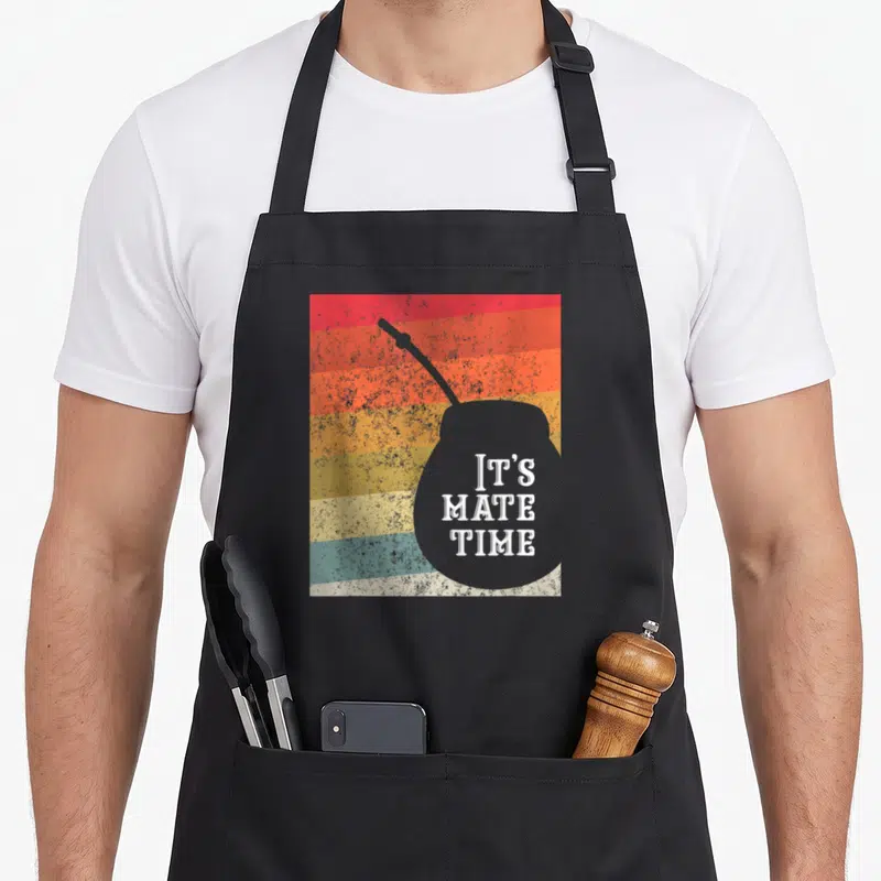 Argentine yerba mate apron - Grey mate gourd silhouette with IT'S MATE TIME text over red orange yellow grey and teal — shown on a black cotton canvas apron against a white background