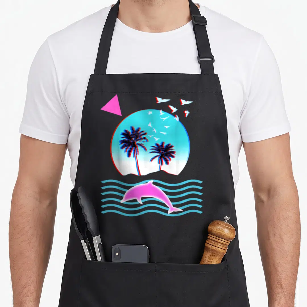 Vaporwave tree apron - Pink dolphin jumping over blue waves below circle with two palm trees and flying white birds — shown on a black cotton canvas apron against a white background