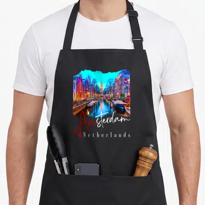 Night amsterdam apron - Canal photo shaped like a map with Amsterdam Netherlands text in blue and red script — shown on a black cotton canvas apron against a white background
