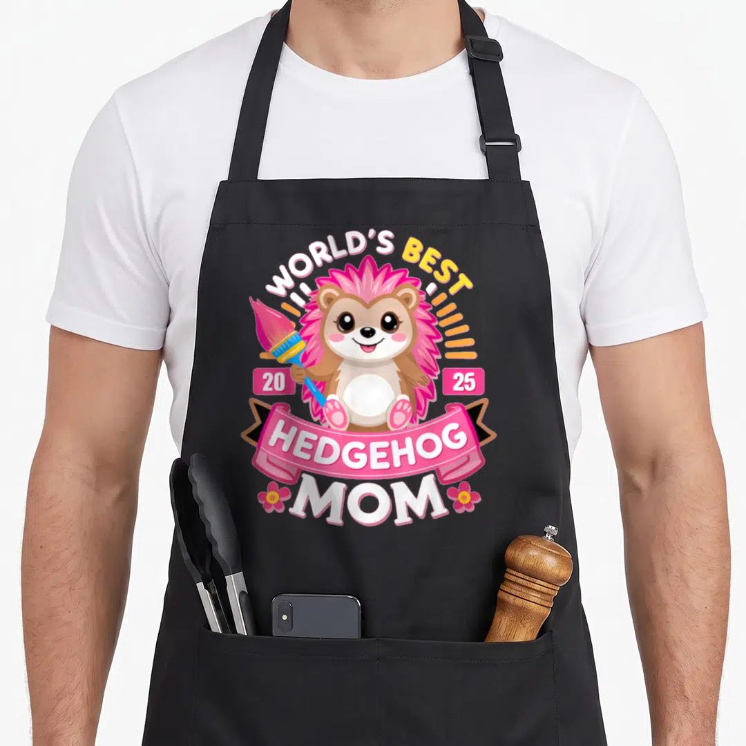 Hedgie hedgehog mom apron - Cartoon hedgehog holding paintbrush with WORLD'S BEST HEDGEHOG MOM text and 2025 date boxes — shown on a black cotton canvas apron against a white background