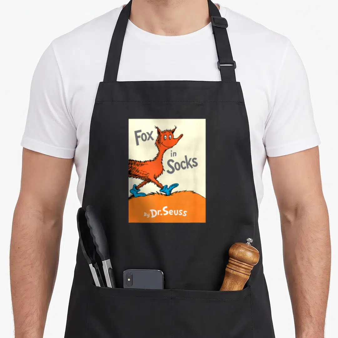 Sock fox print apron - Cartoon fox in blue socks with grey Fox in Socks text on orange ground — shown on a black cotton canvas apron against a white background