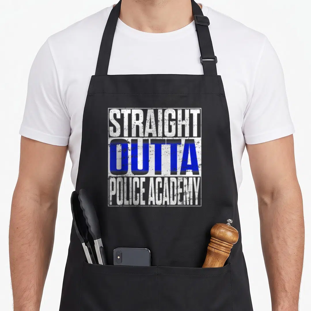 Academy police apron - Stacked distressed text STRAIGHT OUTTA POLICE ACADEMY in white and blue within white border — shown on a black cotton canvas apron against a white background
