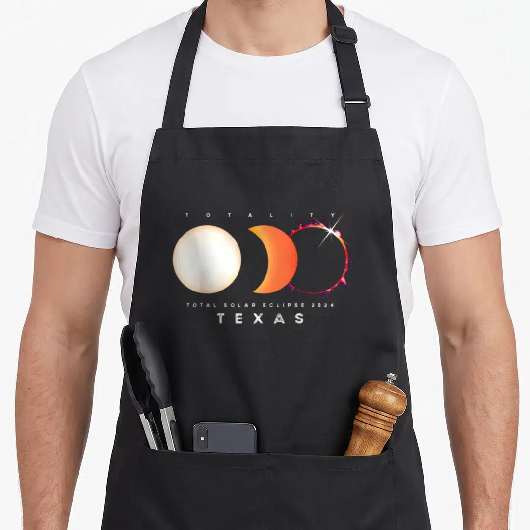 Solar eclipse texas apron - Three eclipse phases in white orange and purple with text Totality Texas 2024 — shown on a black cotton canvas apron against a white background