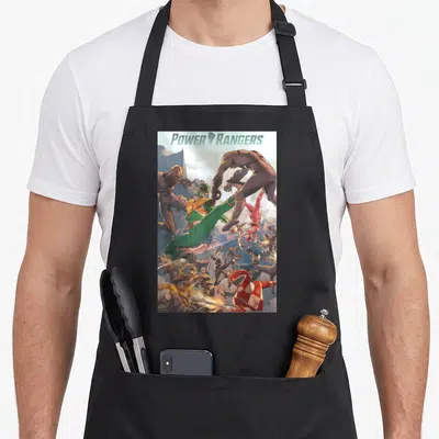Morph rangers apron - Power Rangers text above cartoon heroes in green red blue yellow pink fighting brown monsters — shown on a black cotton canvas apron against a white background