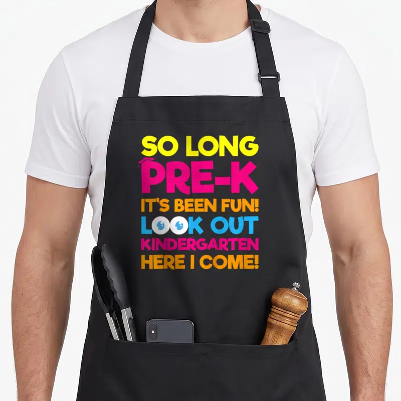 Kindergarten day pre k apron - Stacked text So Long Pre-K with graduation cap and cartoon eyes in yellow pink orange — shown on a black cotton canvas apron against a white background