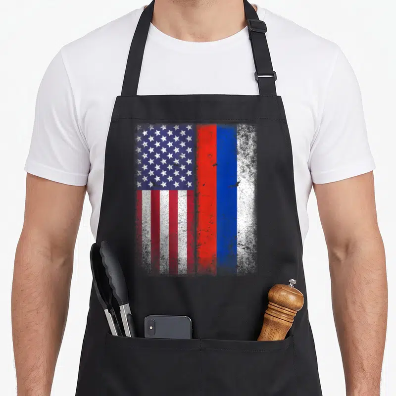 Russian american flag apron - Distressed USA and Russian flags side by side in red white and blue — shown on a black cotton canvas apron against a white background