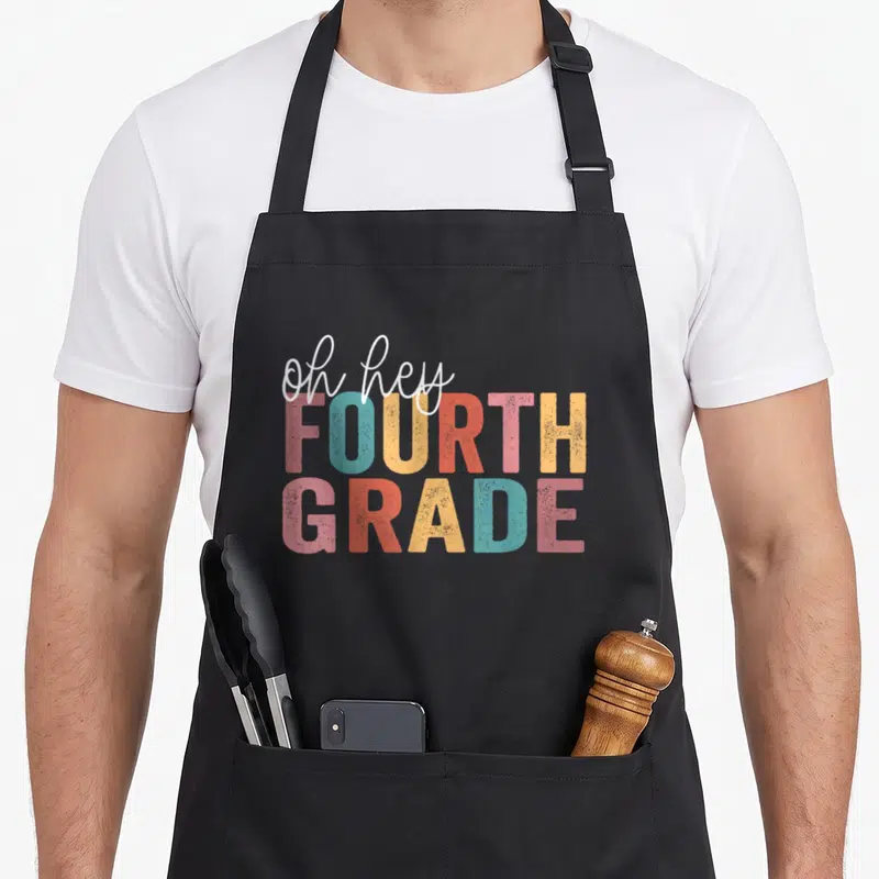Hey fourth teacher apron - Oh hey fourth grade stacked typography in white pink teal yellow orange — shown on a black cotton canvas apron against a white background