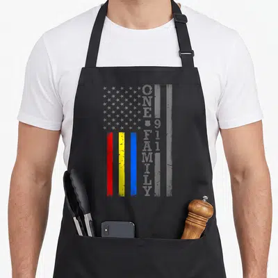 Fire service apron - Distressed grey flag with red yellow blue stripes and vertical One Big Family 911 text — shown on a black cotton canvas apron against a white background