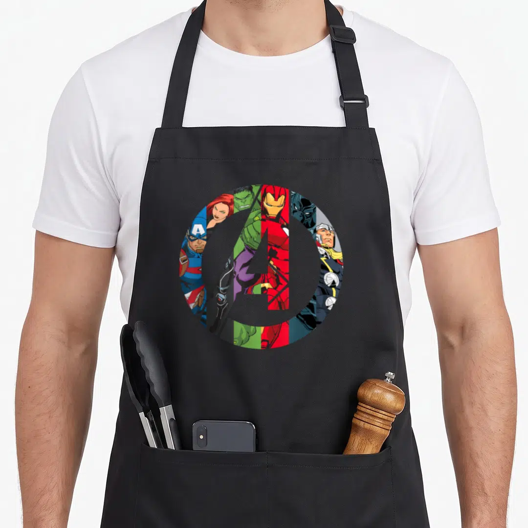 Cute general apron - Grey A logo over vertical superhero slices in red blue green black and grey cartoon style — shown on a black cotton canvas apron against a white background
