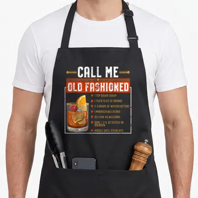 Sarcasm old fashioned aprons - Retro Old Fashioned cocktail recipe with orange slice cherry and whisky bitters text — shown on a black cotton canvas apron against a white background
