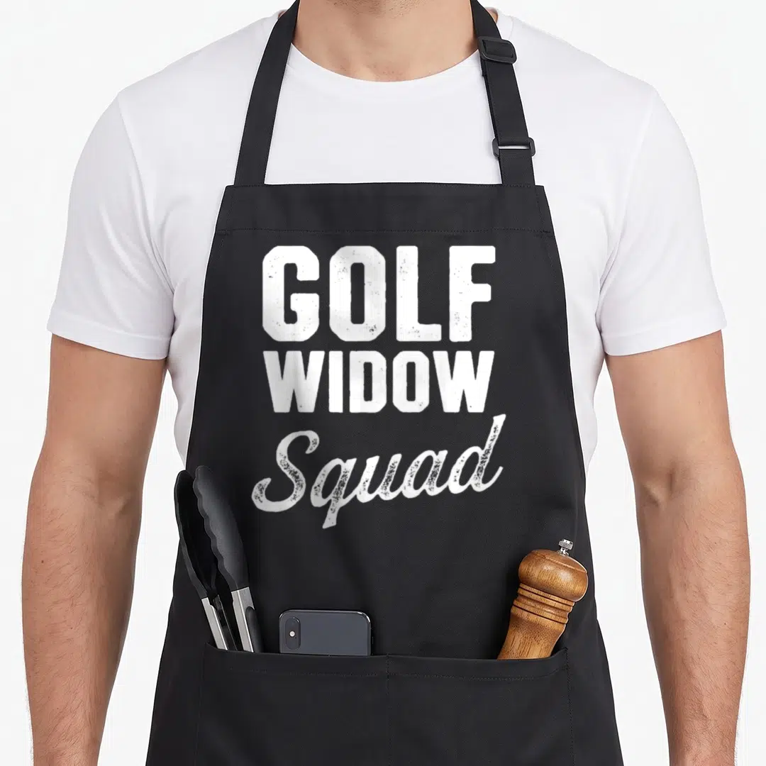 Golf i love my wife apron - White distressed text reading GOLF WIDOW Squad stacked vertically — shown on a black cotton canvas apron against a white background
