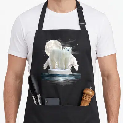 Zoo bear apron - Polar bear standing on ice floe with two others under a moon over dark water — shown on a black cotton canvas apron against a white background