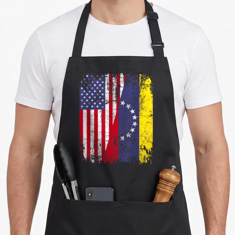 Venezuelan american flag apron - Distressed Venezuelan and American flags merging in red white blue and yellow — shown on a black cotton canvas apron against a white background