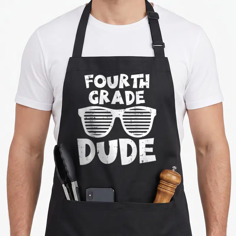 4th dude apron - White distressed shutter shades between FOURTH GRADE and DUDE text — shown on a black cotton canvas apron against a white background