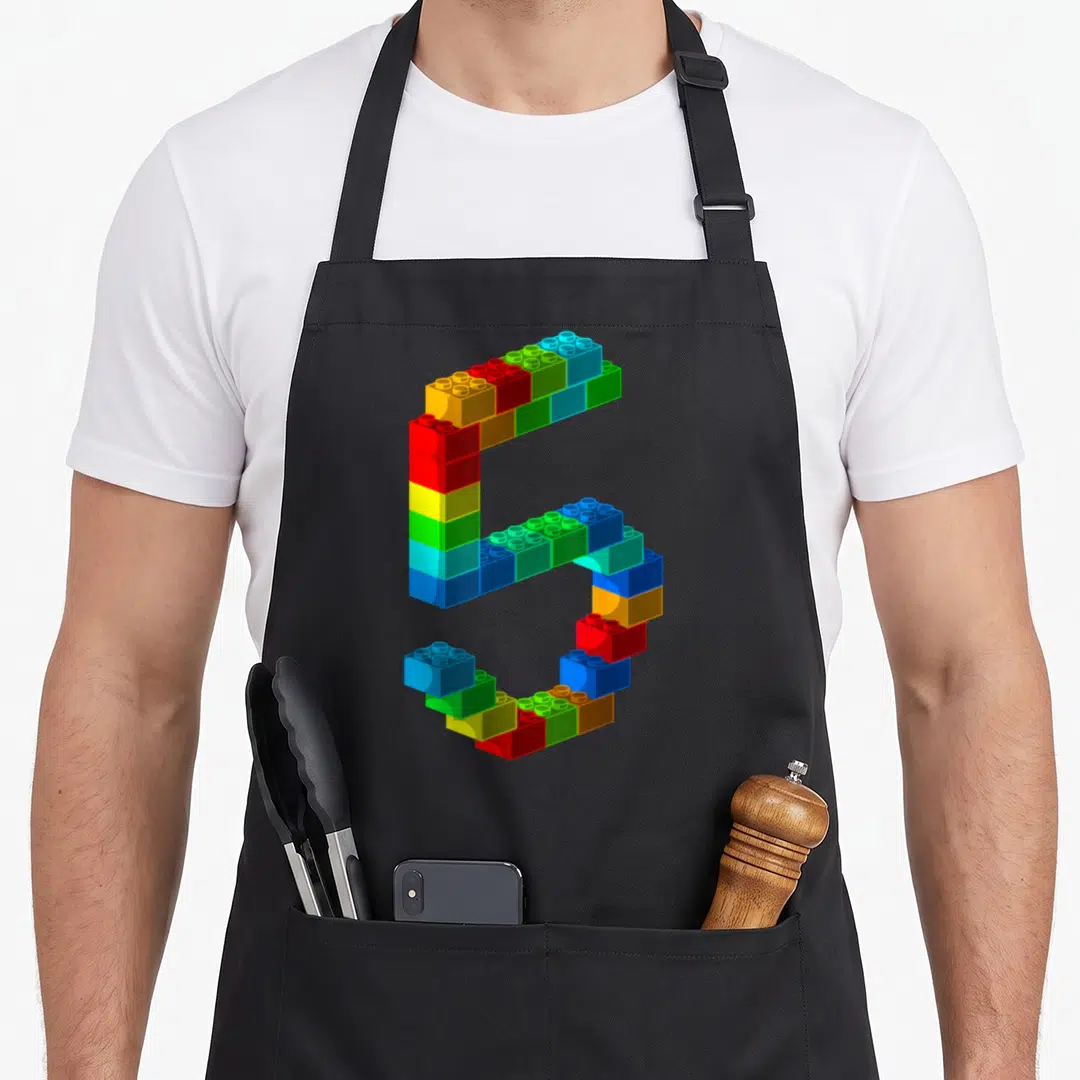 5th building aprons - Number 5 formed from red yellow green blue and orange toy blocks — shown on a black cotton canvas apron against a white background
