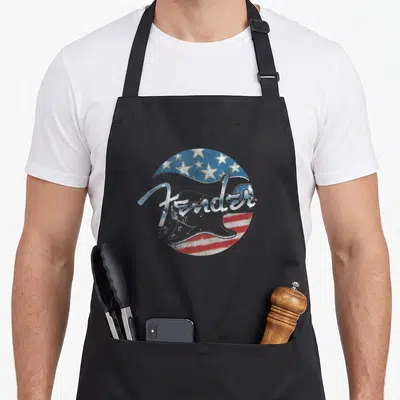 Fender 4th of july apron - Distressed circular badge with Fender script, electric guitar silhouette, and red white — shown on a black cotton canvas apron against a white background