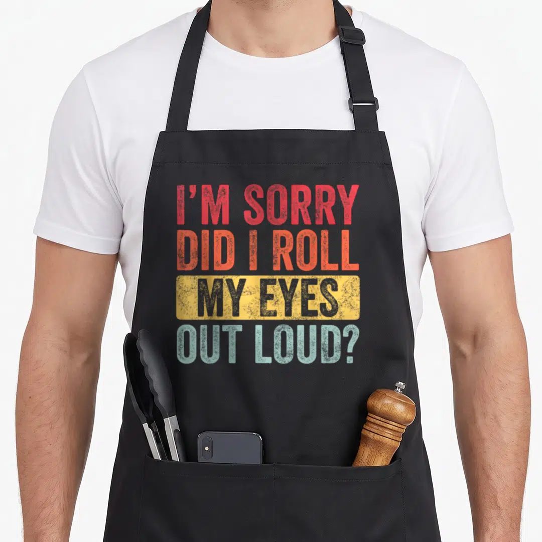 Roll sorry apron - Stacked text reading I'M SORRY DID I ROLL MY EYES OUT LOUD in red orange yellow and light blue — shown on a black cotton canvas apron against a white background