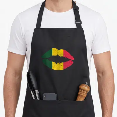 Reggae reggaeton apron - Distressed lips with vertical green yellow red stripes — shown on a black cotton canvas apron against a white background