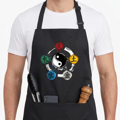 Element qigong apron - Yin yang surrounded by five colored spheres with kanji in white brush circle — shown on a black cotton canvas apron against a white background