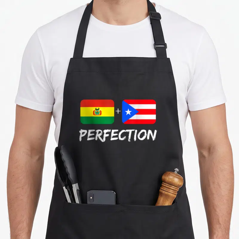 Bolivian heritage aprons - Two flags side by side with a plus sign and the word PERFECTION below — shown on a black cotton canvas apron against a white background