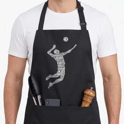 Player youth volleyball apron - White typographic silhouette of a volleyball player formed by words like ACE, SET — shown on a black cotton canvas apron against a white background