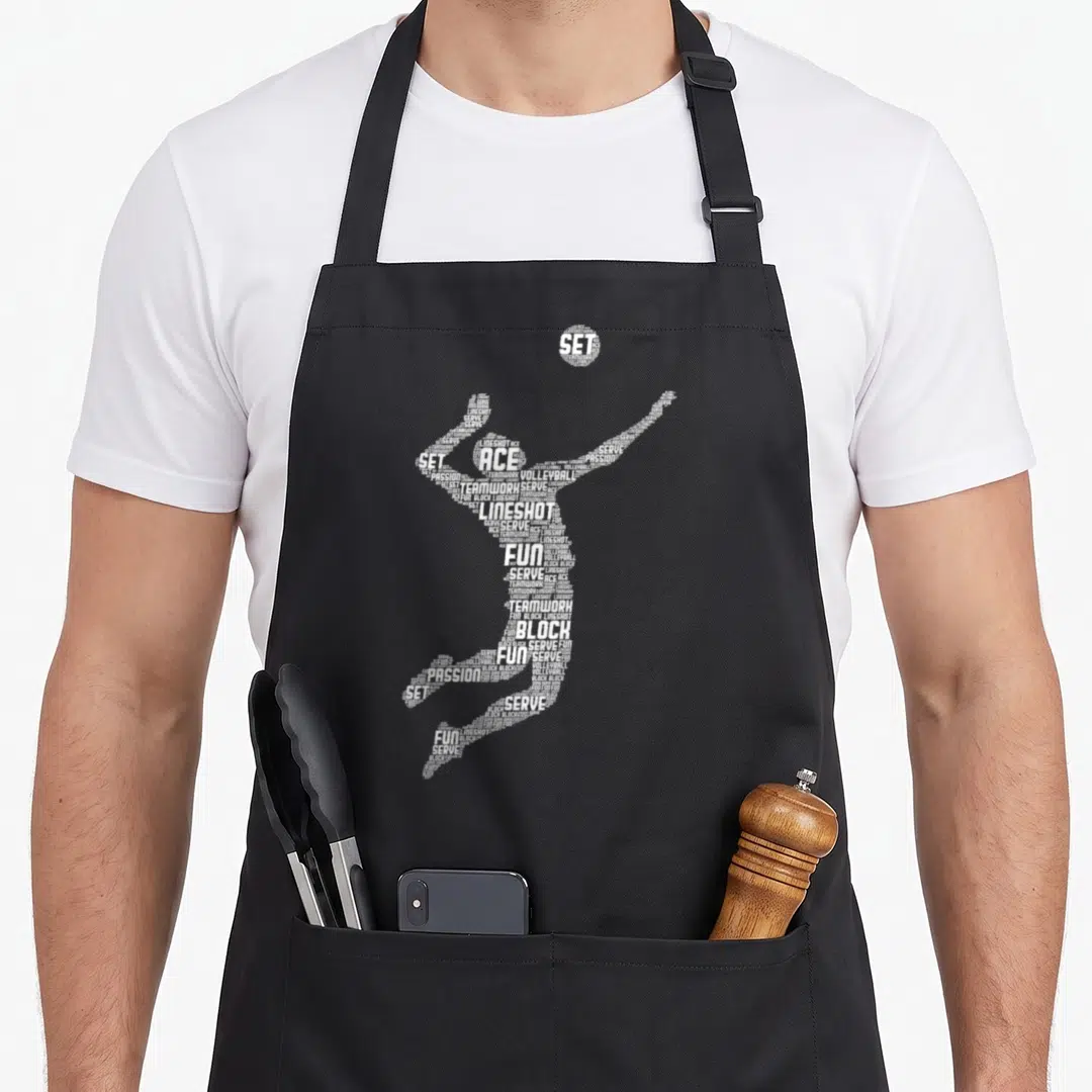 Player youth volleyball apron - White typographic silhouette of a volleyball player formed by words like ACE, SET — shown on a black cotton canvas apron against a white background