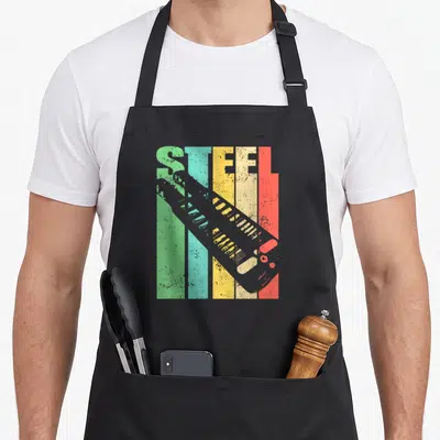 Lap classic rock apron - Retro STEEL text over green teal yellow red grey stripes with diagonal grey boot silhouette — shown on a black cotton canvas apron against a white background