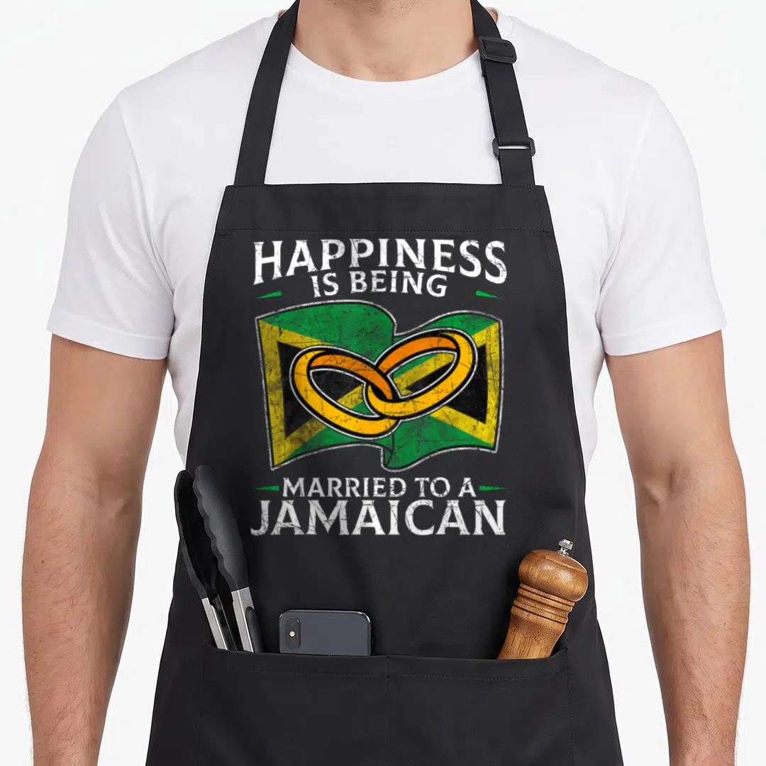 Marriage heritage aprons - Distressed Jamaican flag with two interlocking gold rings and white text — shown on a black cotton canvas apron against a white background