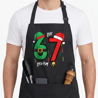 Youth christmas apron - Number 67 with elf hat on six and santa hat on seven with bell — shown on a black cotton canvas apron against a white background